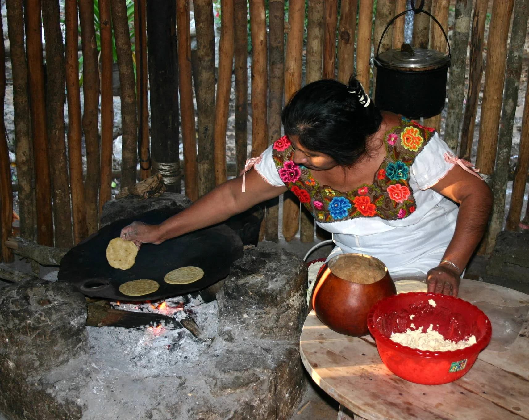 Mujer torteando frente al comal caliente