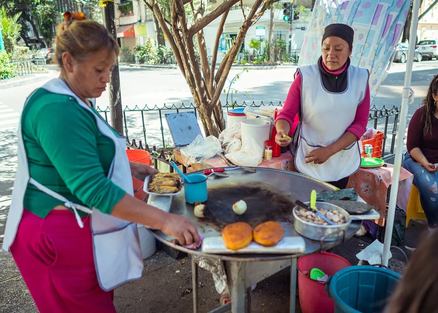 Puesto callejero con cazuelas de guisado y salsas sobre una mesa