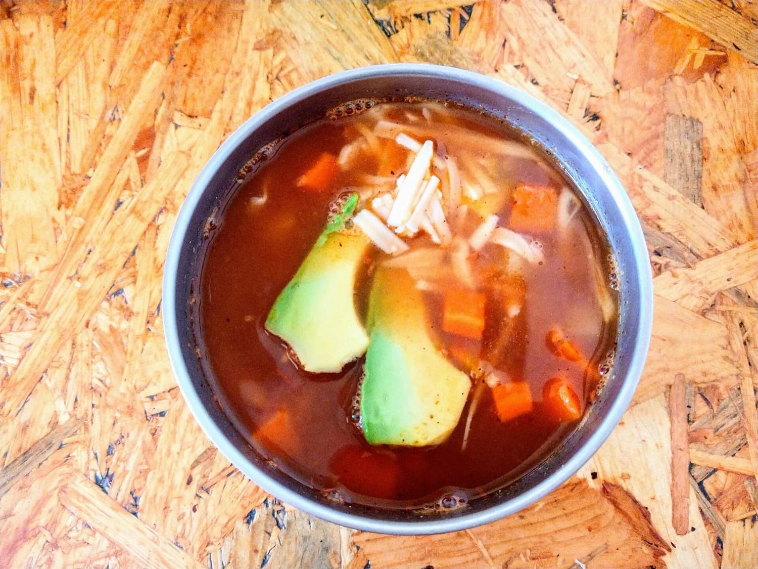 Manos sirviendo un caldo caliente desde la olla