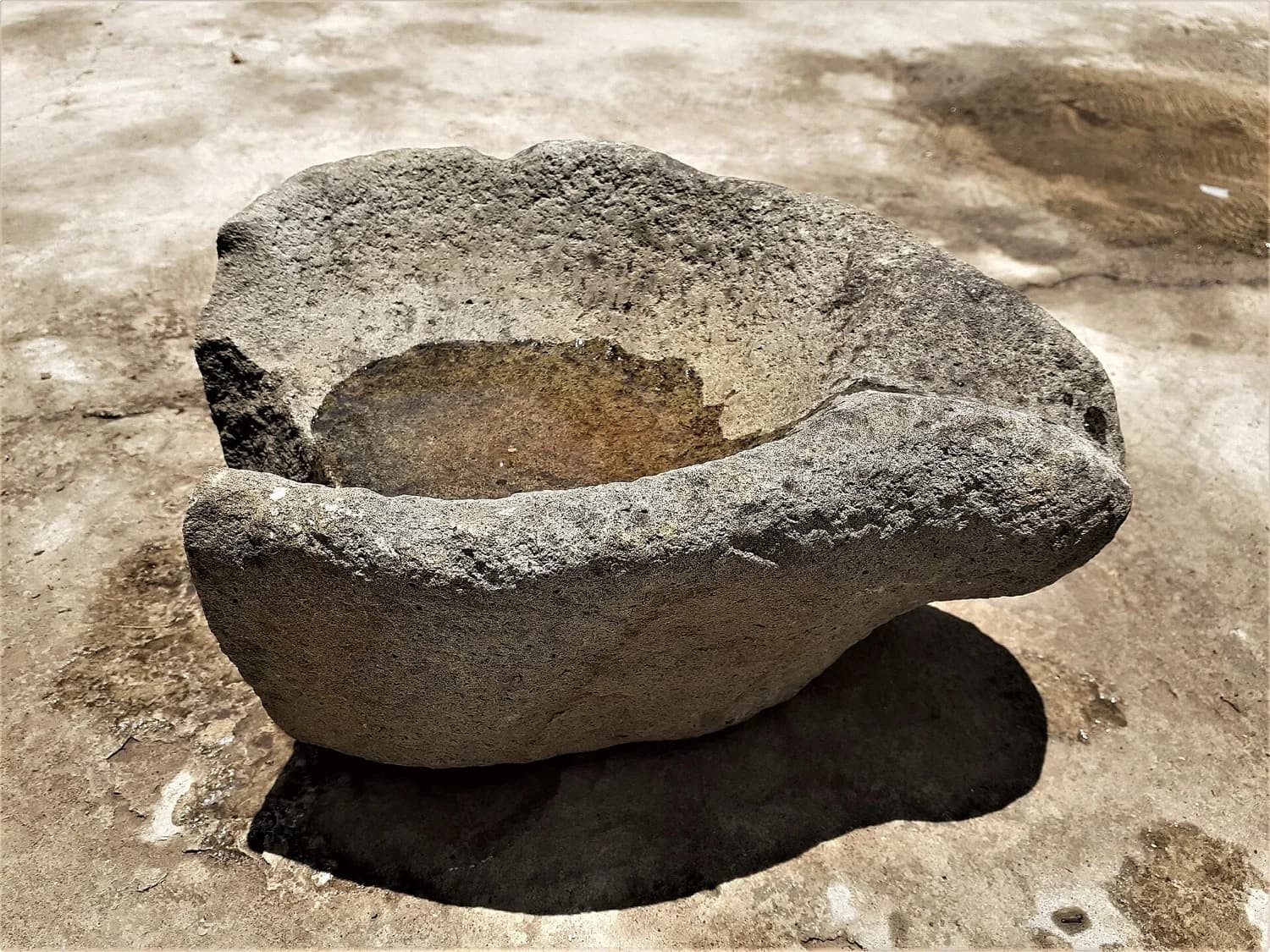 Manos moliendo en un molcajete sobre la mesa de cocina
