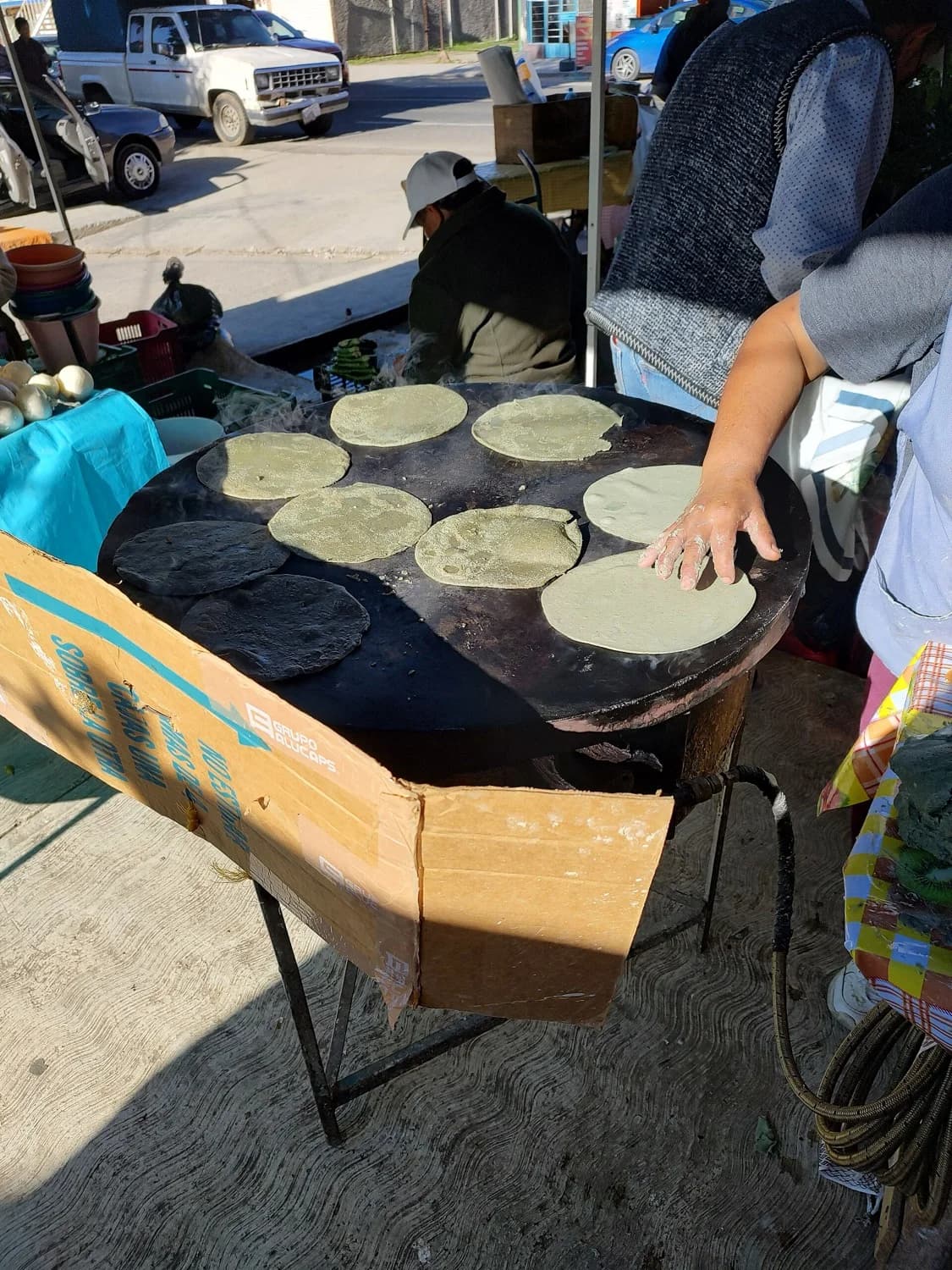Tortillas cociéndose sobre un comal de barro al fuego