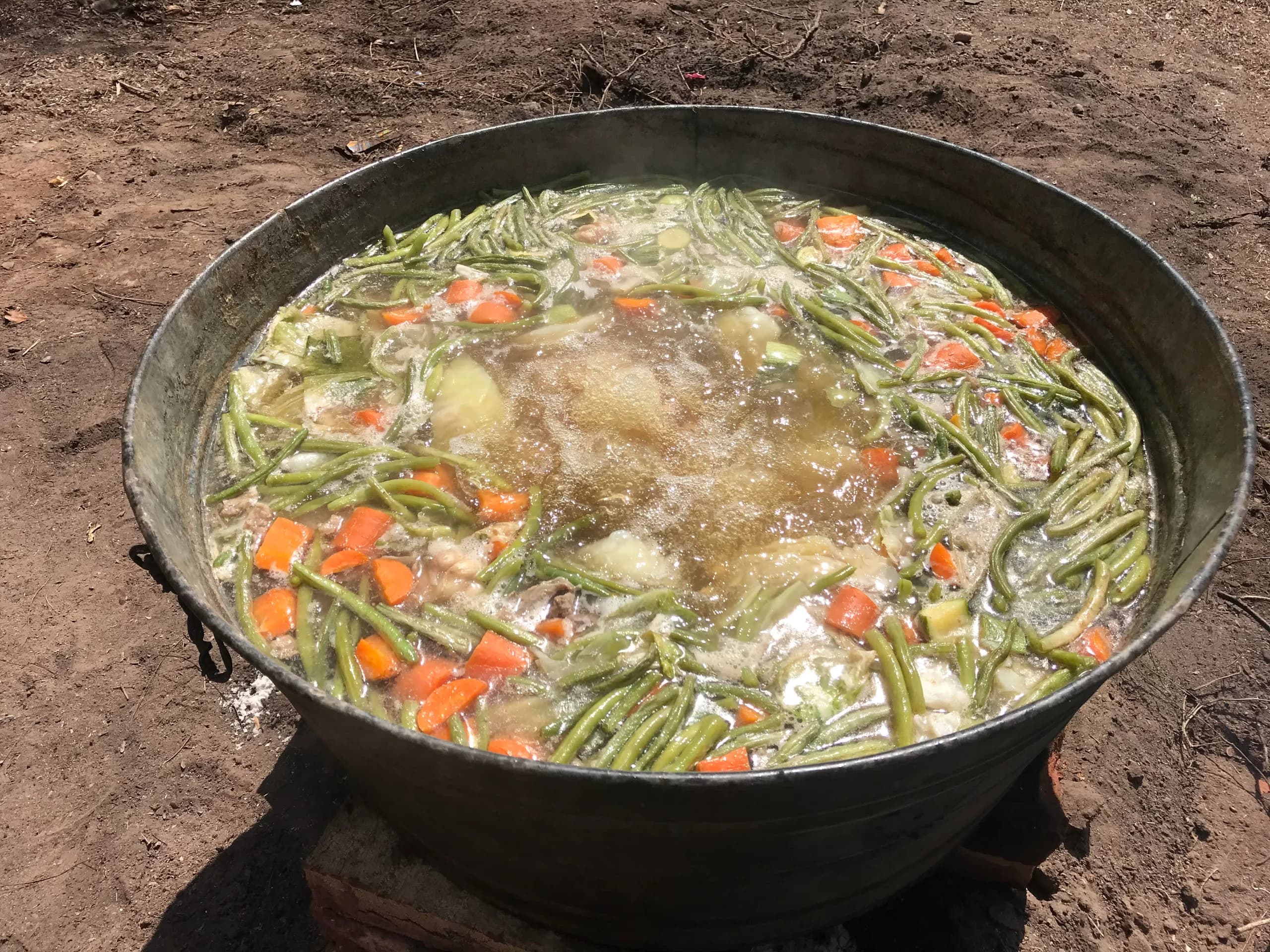 Olla con verduras cociéndose dentro de un caldo de res